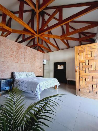 a bedroom with a bed and a wooden ceiling at Duineveld Self Catering Cottage in Kalkrand