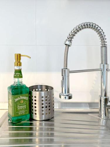 a green bottle of soap next to a sink at Thomas House on Train Tracks in Mestre