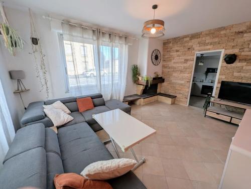 - un salon avec un canapé bleu et un mur en briques dans l'établissement Dod's location 2, à Bordeaux