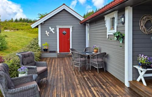 a deck with a red door and a table with chairs at Cozy Home In Florø With Wifi in Florø