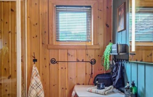 a kitchen with wooden walls and a room with a table at Cozy Home In Florø With Wifi in Florø