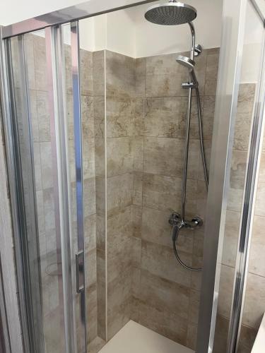 a shower stall with a glass door and a shower at Casa Malù in Valsolda