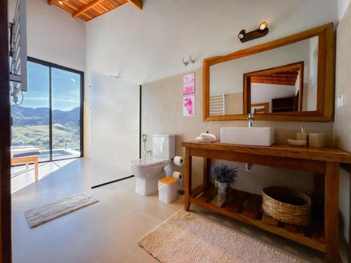a bathroom with a sink and a mirror at Chalé - Vila Bertina in Gonçalves