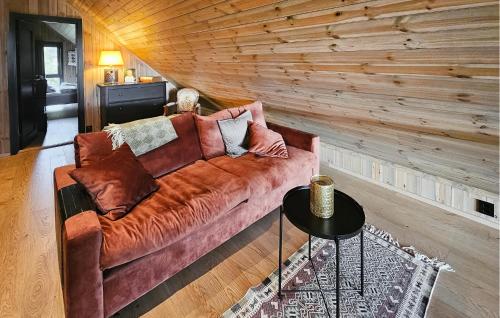 a couch in a living room with a wooden wall at Stunning Home In Nesbyen With Wifi in Nesbyen