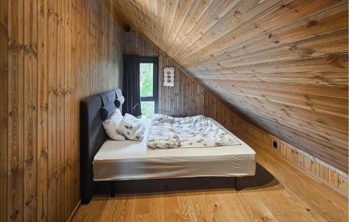 a bed in a room with a wooden wall at Stunning Home In Nesbyen With Wifi in Nesbyen