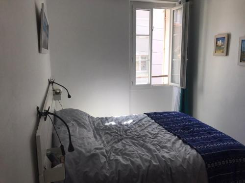 une chambre avec un lit dans une pièce avec une fenêtre dans l'établissement La petite oasis, newly renovated, à Toulon