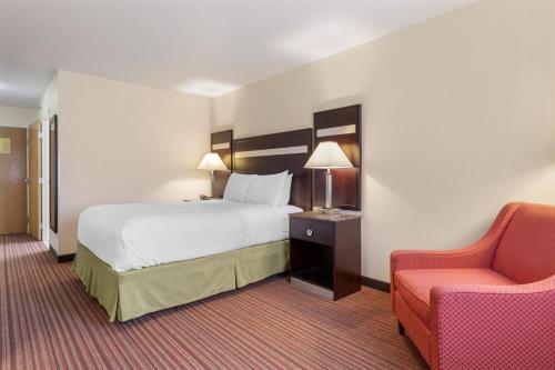 a hotel room with a bed and a chair at Best Western Parsons Inn in Parsons