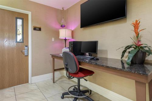 a room with a desk with a computer and a chair at Best Western Parsons Inn in Parsons
