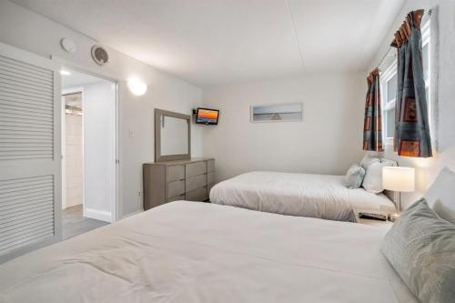 Un dormitorio blanco con dos camas y un espejo. en 6201 Ocean Ave, Unit 302 - The Nassau Inn, en Wildwood