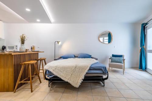 een slaapkamer met een bed, een tafel en stoelen bij Séjour charmant à L'Écrin du Lez in Castelnau-le-Lez