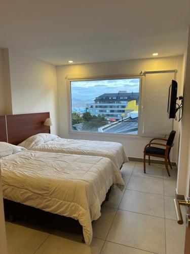 een slaapkamer met twee bedden en een groot raam bij Antártida Argentina 63 in Ushuaia