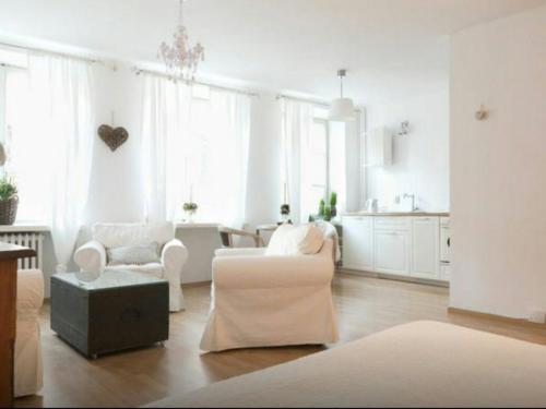un soggiorno con mobili bianchi e una cucina di Piwna Vintage Apartment a Varsavia