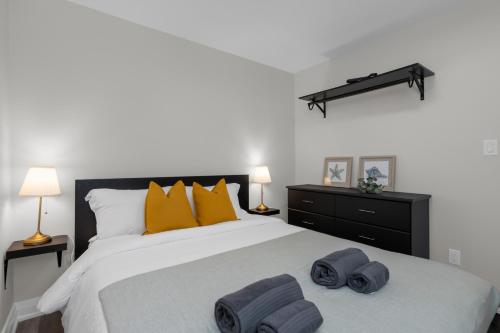 a bedroom with a large bed with towels on it at Adrian's Suites 2 Bedroom Family Suite in Wasaga Beach