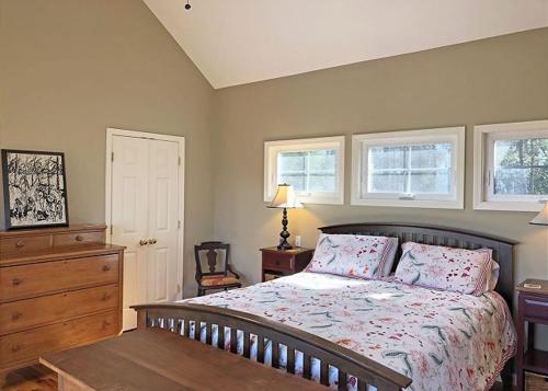 a bedroom with a bed and a dresser and two windows at Pet-Friendly Getaway With Spectacular Mountain View in Saluda