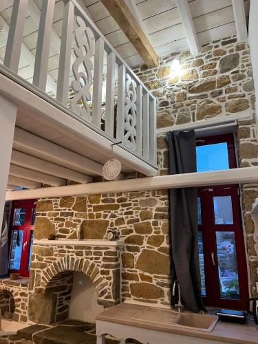 a stone fireplace in a house with a staircase at Rodakas Rooms-Aimilia in LivadhokhÃ³rion