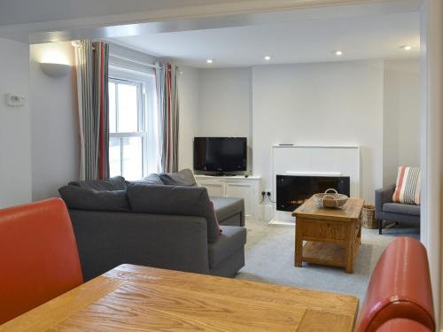 a living room with a couch and a tv at Coastguard Cottage in Ryde