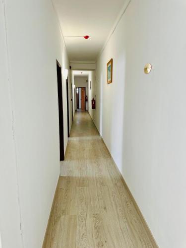 a long hallway with white walls and a wooden floor at Residencial Pimenta ,Portimao,Algarve in Portimão