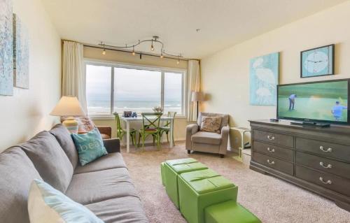 a living room with a couch and a flat screen tv at Sea Gypsy Rentals - Oceanfront Suite in Lincoln City