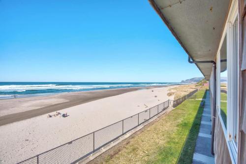 a view of the beach from the balcony of a beach house at Sea Gypsy Rentals - Oceanfront Suite in Lincoln City