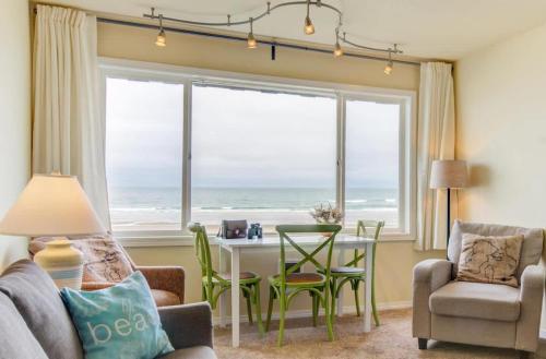 a living room with a table and a view of the ocean at Sea Gypsy Rentals - Oceanfront Suite in Lincoln City