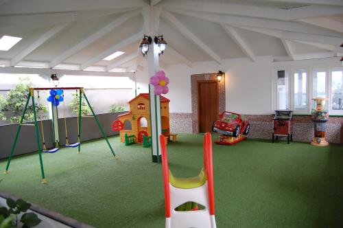 a room with a play area with a slide and swings at Hotel Ristorante Donato in Calvizzano