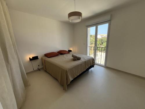 une chambre avec un lit et une grande fenêtre dans l'établissement Calvi - A Casa di u Mare, à Calvi