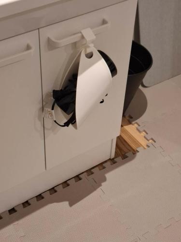 a hole in a white cabinet in a bathroom at 駐車場無料 Nagoya Hostel The Three Smiles Free Car Park in Nagoya