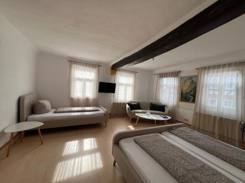 a hotel room with two beds and a couch at Hotel und Restaurant Zum Löwen in Gelnhausen