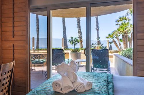 a bedroom with towels on a bed with a view of the ocean at Pacific Terrace Hotel in San Diego