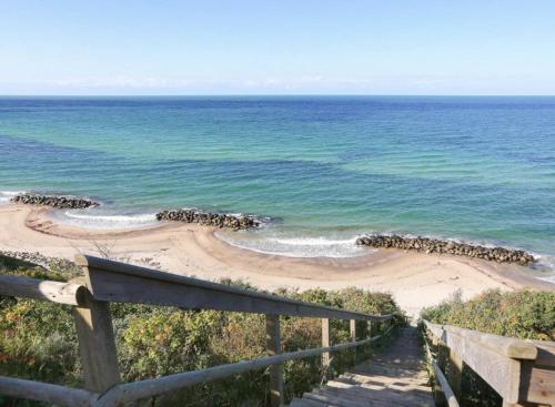 a stairway leading to a beach next to the ocean at Family Idyll Near Kattegat In Tisvilde in Tisvildeleje