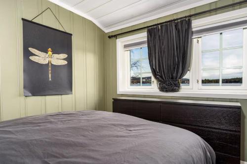 ein Schlafzimmer mit einem Bett und zwei Fenstern in der Unterkunft Lakeside Cabin Near Sjusjøen And Lillehammer in Mesnali