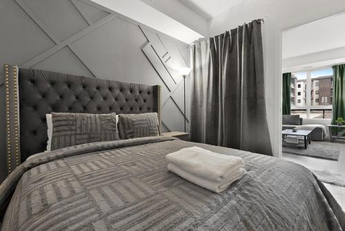 1 dormitorio con cama grande y almohada blanca en Cozy 2BR Suite Only 8 Mins to The Falls With Sofa Bed And Sleeps 6, en Niagara Falls