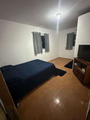 a bedroom with a bed and a flat screen tv at Suíte no centro in Saquarema