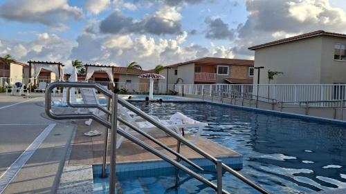 ein Schwimmbad mit einer Treppe, die in ein Gebäude führt in der Unterkunft Apto resort perto da praia e do centro de Aracaju in Barra dos Coqueiros