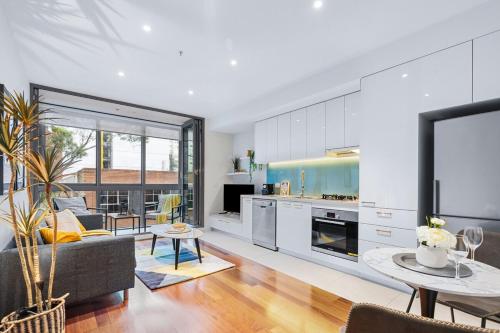 a kitchen and living room with a couch and a table at The South Yarra Jewel in Melbourne