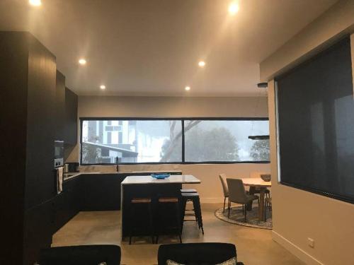 a room with a table and chairs and a large window at Konayuki Penthouse 9 in Falls Creek