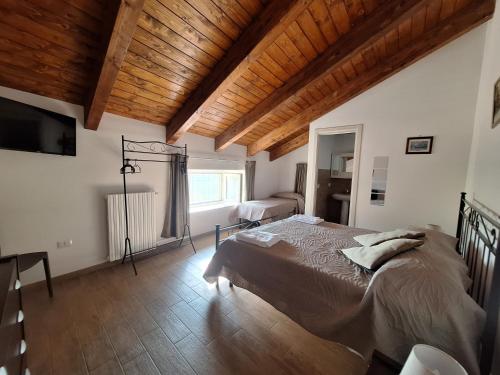 a bedroom with a large bed and a wooden ceiling at Casa Helvius - Dimora in centro storico in Sant'Egidio del Monte Albino