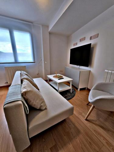 a living room with a couch and a flat screen tv at Explore Tarazona from This Central & Peaceful Flat in Tarazona de Aragón