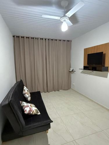 a living room with a couch and a flat screen tv at Casa de campo Pôr do Sol in Brotas