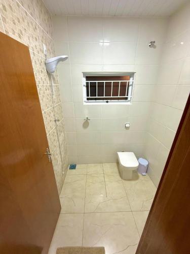 a bathroom with a toilet and a window at Casa de campo Pôr do Sol in Brotas