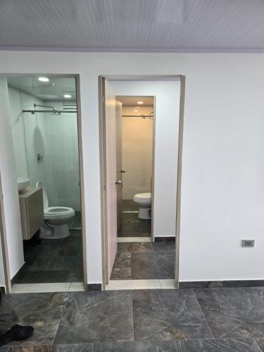 a bathroom with two toilets and two sinks at Vancouver 102 in Villamaría