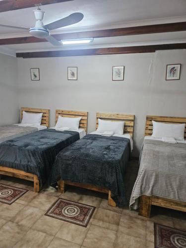 a room with two beds and a ceiling fan at MP Stop Guest House in Rustenburg