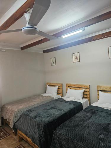 two beds in a room with a ceiling at MP Stop Guest House in Rustenburg