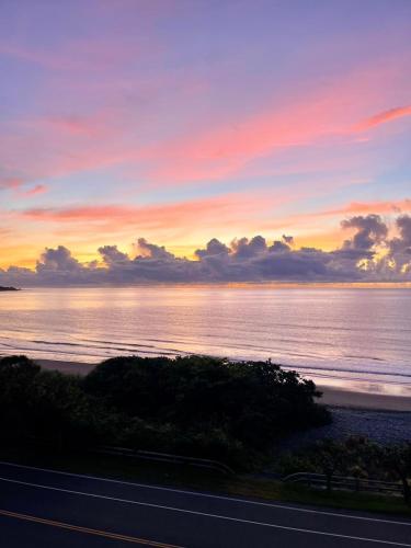 a sunset over the ocean with a road in the foreground at Taitung Blue Sea Villa in Chenggong