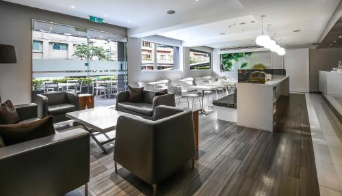 a restaurant with couches and tables and windows at Dandy Hotel - Tianmu Branch in Taipei