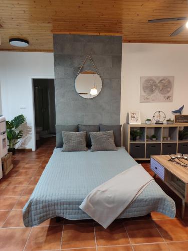 a bedroom with a large blue bed with a mirror at Casa do Moinho in Lajes do Pico