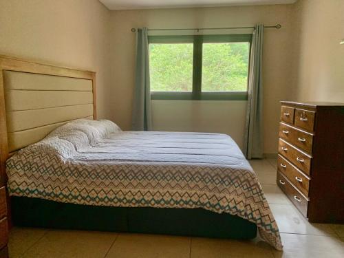 a bedroom with a bed and a dresser and a window at Apartemento nuevo totalmente amueblado en zona muy tranquila y segura 75 m2 con balcon y plaza de aparcamiento in San Lorenzo de la Frontera