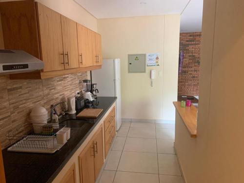 a kitchen with wooden cabinets and a black counter top at Apartemento nuevo totalmente amueblado en zona muy tranquila y segura 75 m2 con balcon y plaza de aparcamiento in San Lorenzo de la Frontera