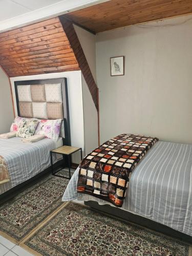 a bedroom with two beds and a table in it at MP Stop Guest House in Rustenburg