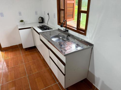 a small kitchen with a sink and a stove at Cabanas Belvedere in Louro Müller
